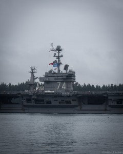 USS Stennis flying the 12thMan flag while leaving for deployment